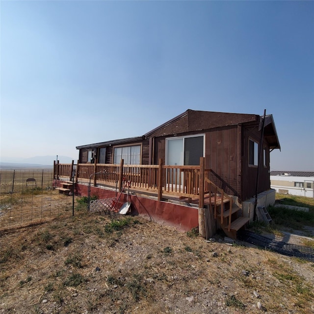 back of house with fence and a deck