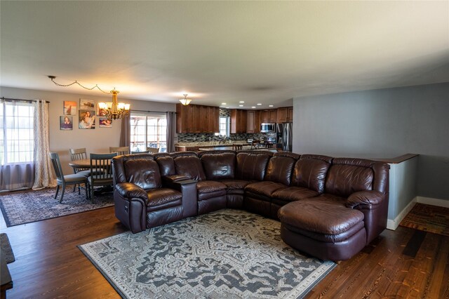 living room with dark wood-style flooring, baseboards, a notable chandelier, and recessed lighting