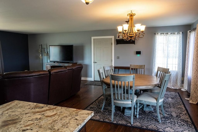 dining area featuring dark wood-style flooring and a notable chandelier