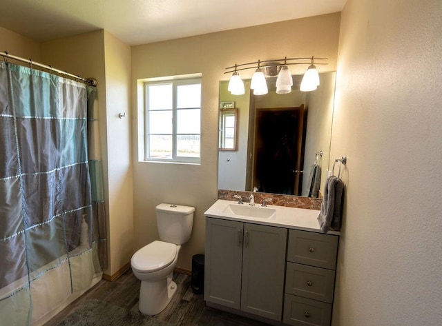 full bath with vanity, wood finished floors, and toilet
