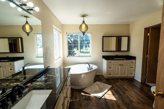 700 Stone St, Kalispell, MT 59901 - bathroom with two vanities, wood finished floors, and a freestanding bath