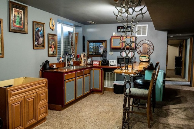 bar with a sink, light carpet, stainless steel microwave, and visible vents
