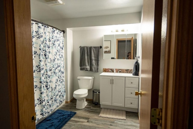 full bathroom featuring vanity, toilet, wood finished floors, a shower with curtain, and visible vents
