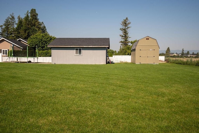 view of yard featuring a fenced backyard, a storage unit, and an outbuilding
