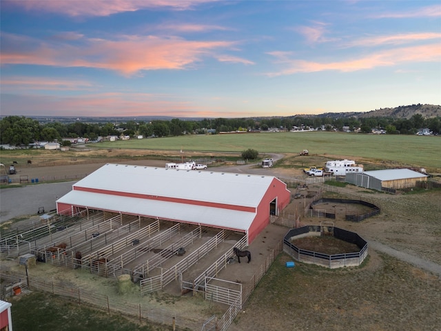 aerial view at dusk with a water view and a rural view