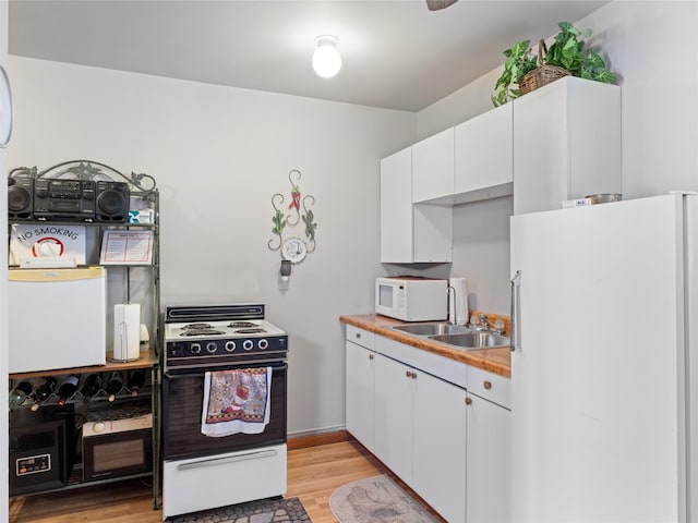 kitchen featuring sink, white appliances, white cabinetry, and light hardwood / wood-style floors