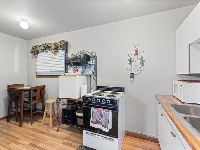 kitchen with light hardwood / wood-style flooring, white appliances, white cabinets, sink, and butcher block counters