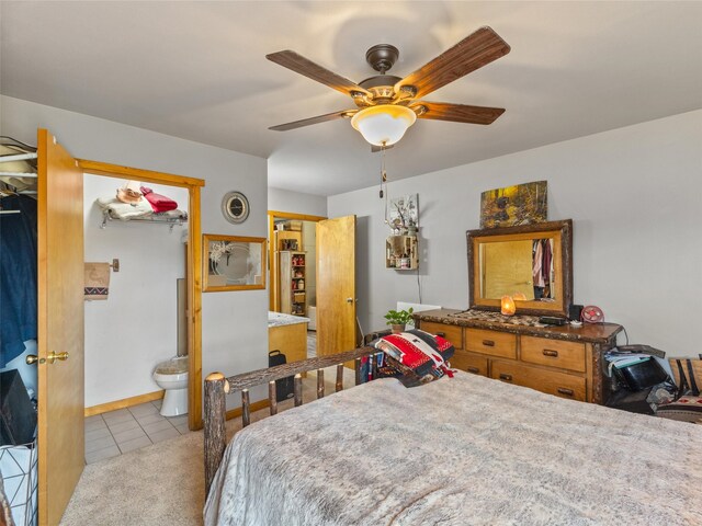 tiled bedroom featuring ensuite bath and ceiling fan