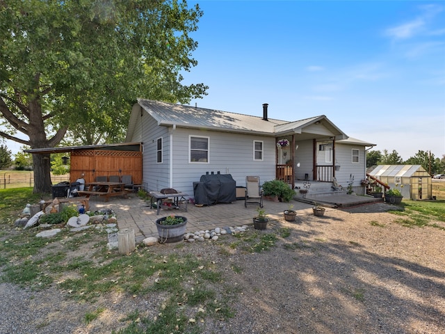 back of property with a patio and an outdoor structure