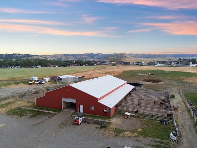 aerial view at dusk with a mountain view and a rural view