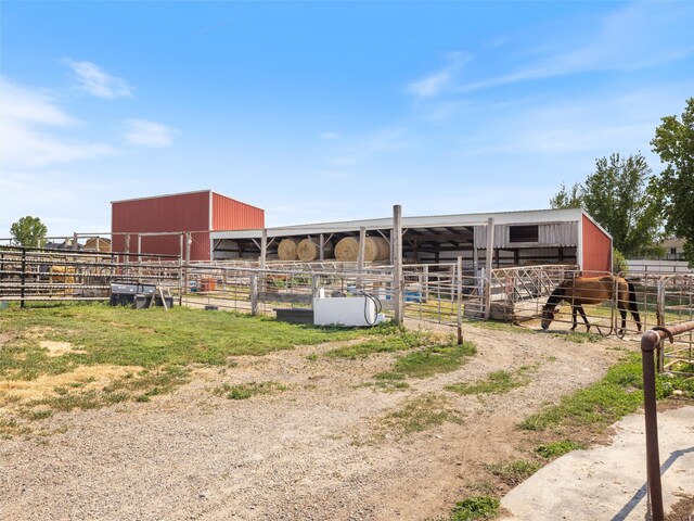 view of horse barn with an outbuilding and a rural view