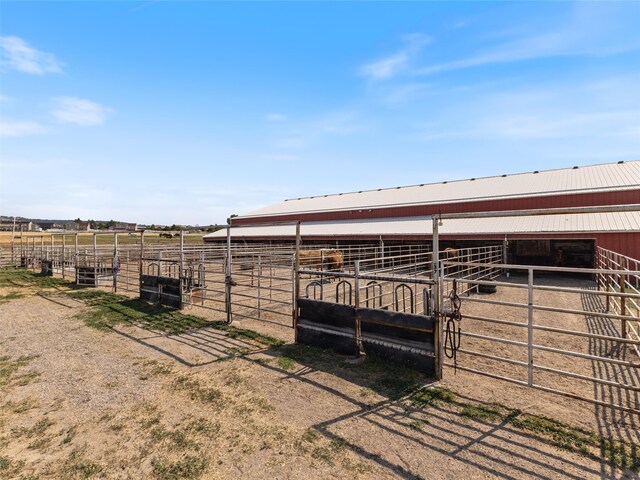 view of stable featuring a rural view and an outbuilding