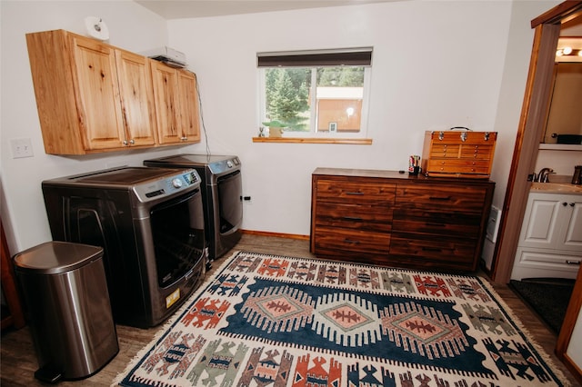 laundry room featuring cabinets, sink, washer and dryer, and hardwood / wood-style flooring