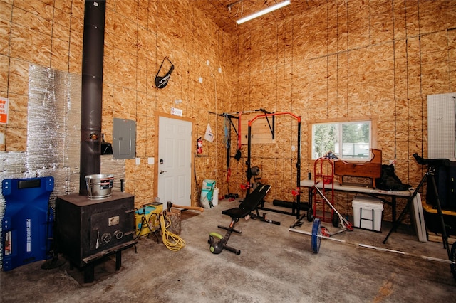 workout room with a towering ceiling and electric panel