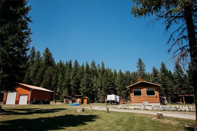 view of yard featuring a garage and an outbuilding