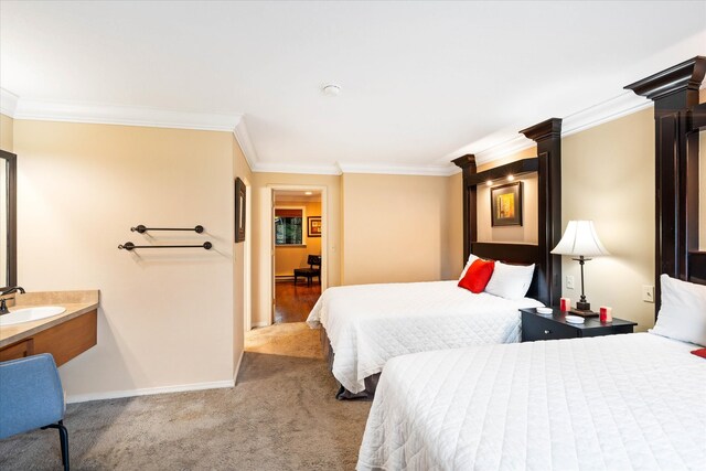 carpeted bedroom featuring sink and crown molding