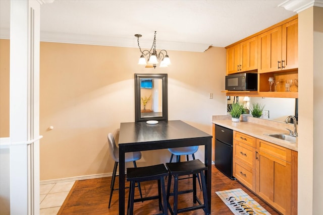 kitchen with pendant lighting, sink, a notable chandelier, fridge, and light tile patterned floors