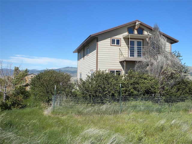 view of side of property with fence and a mountain view