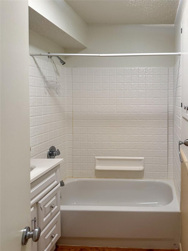 full bathroom featuring a textured ceiling, vanity, and shower / bathtub combination