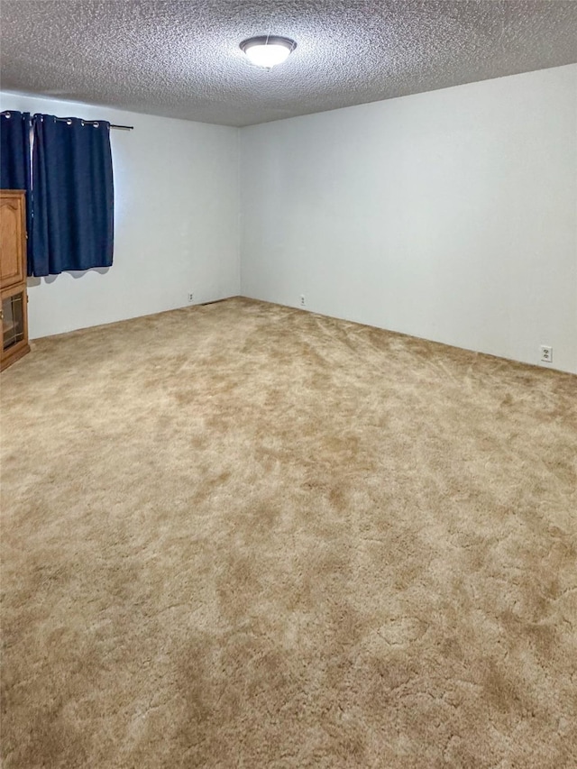 carpeted spare room featuring a textured ceiling