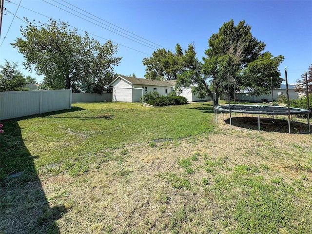 view of yard featuring a trampoline and fence