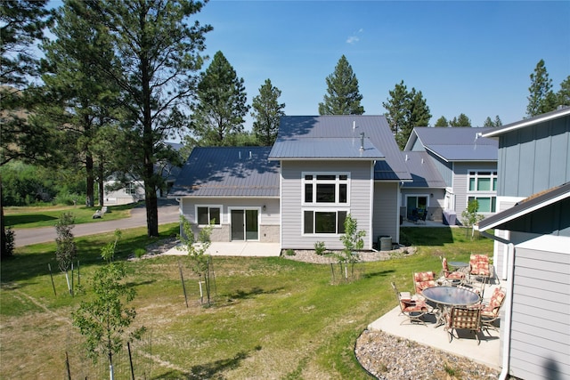 rear view of property featuring a patio and a lawn