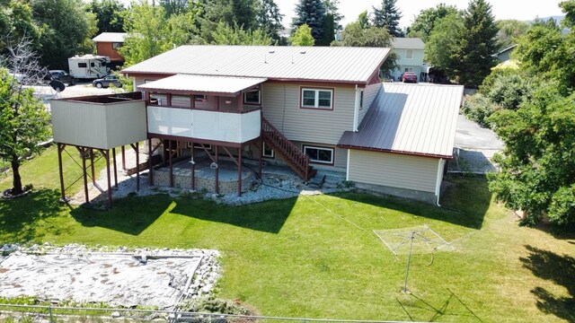 back of property featuring stairs, a patio, a wooden deck, metal roof, and a lawn