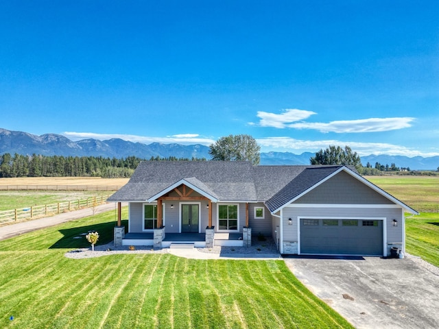 single story home with a garage, a front lawn, and a mountain view