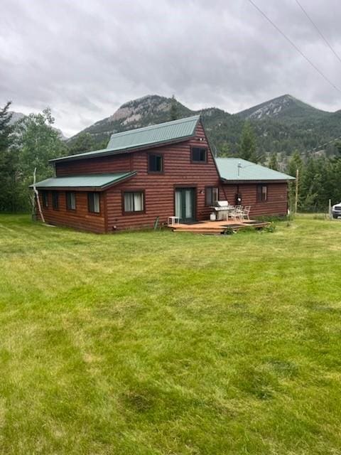 back of house featuring a deck with mountain view and a yard