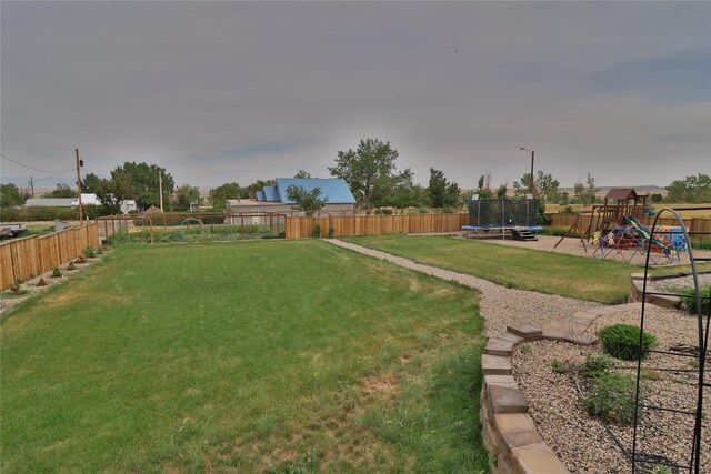 view of yard featuring a playground and a trampoline