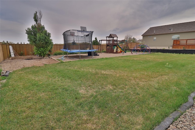 view of yard with a fenced backyard, a trampoline, and a playground