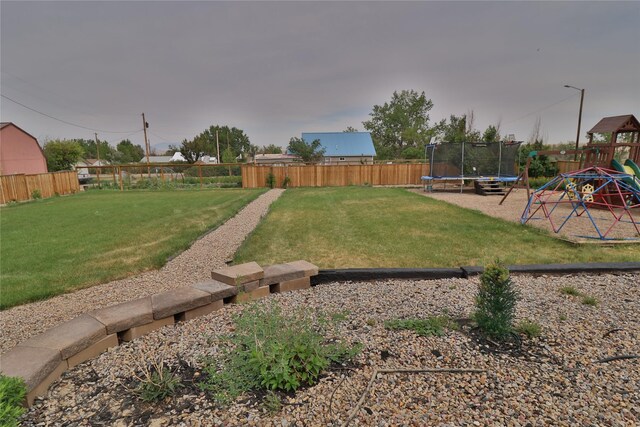 view of yard featuring a trampoline and a playground