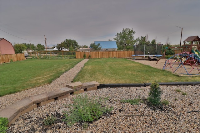 view of yard with a fenced backyard, a trampoline, and a playground