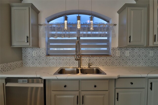 kitchen with gray cabinets, tasteful backsplash, sink, stainless steel dishwasher, and light stone countertops