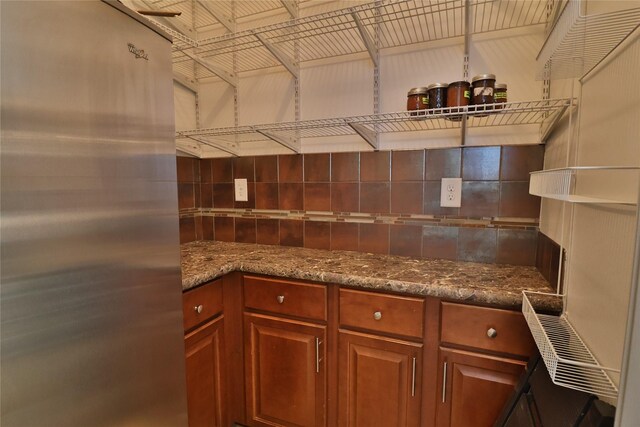 kitchen featuring stone countertops and stainless steel fridge