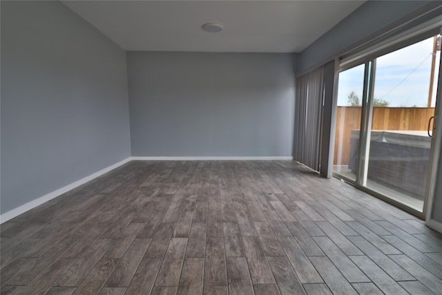 unfurnished room with dark wood-type flooring and baseboards