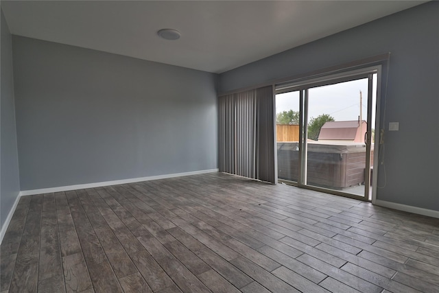 unfurnished room featuring baseboards and wood finished floors