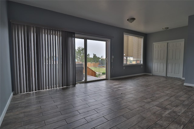 empty room featuring dark wood finished floors and baseboards