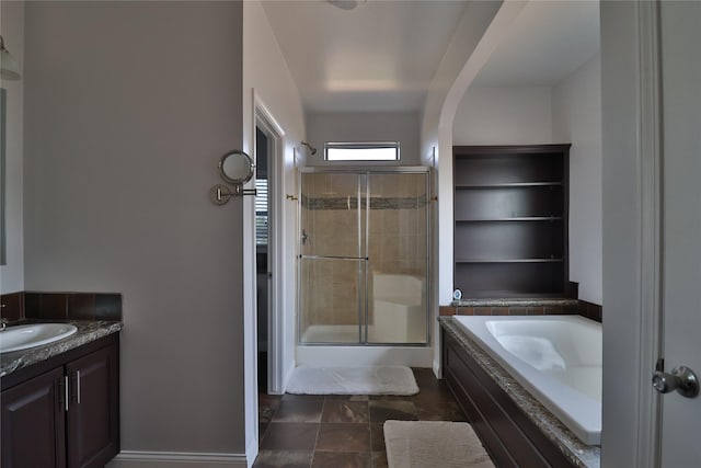 bathroom featuring a stall shower, a bath, and vanity