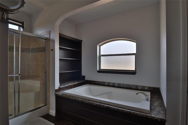 bathroom with a stall shower and a garden tub