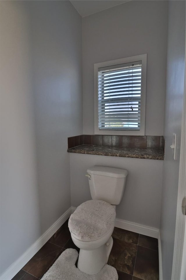 bathroom featuring tile patterned floors, toilet, and baseboards