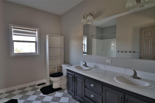 bathroom featuring double vanity, a sink, toilet, and tile patterned floors