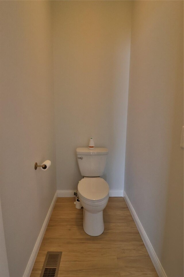 bathroom featuring hardwood / wood-style flooring and toilet