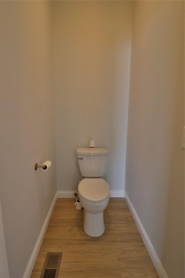 bathroom featuring baseboards, visible vents, and wood finished floors