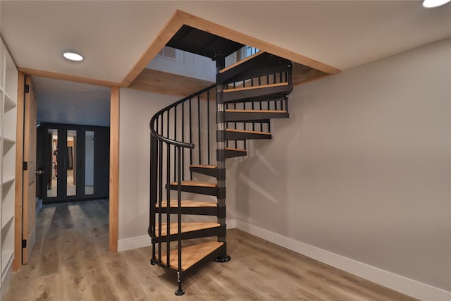 stairs featuring hardwood / wood-style floors