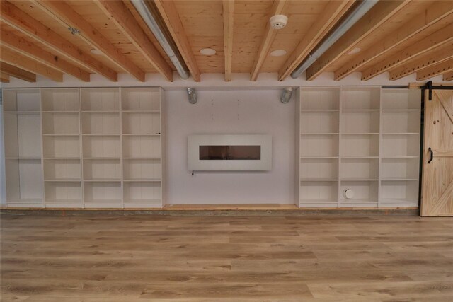 unfurnished living room featuring wood-type flooring and a barn door