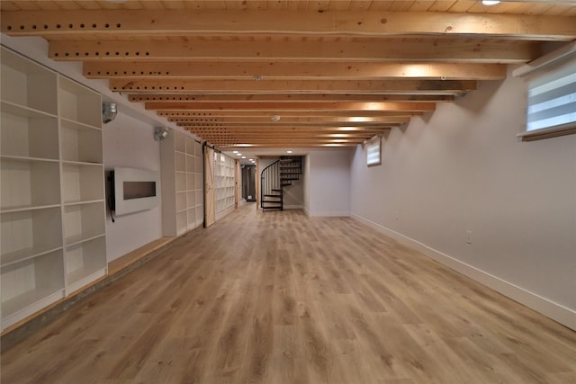 basement featuring stairway, baseboards, and wood finished floors