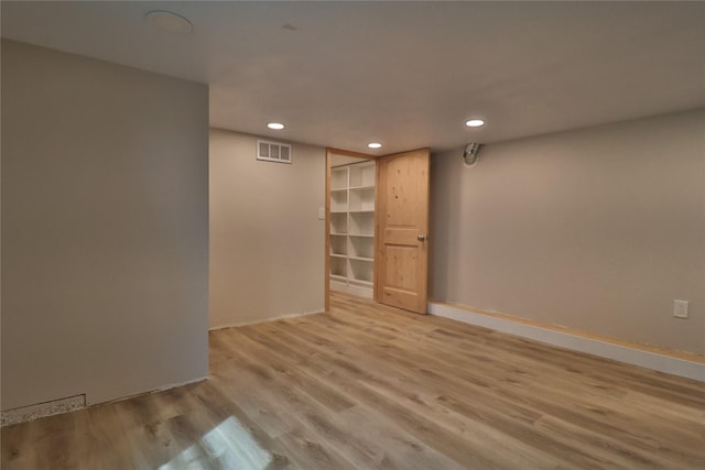 finished basement featuring light wood-style floors, recessed lighting, visible vents, and baseboards