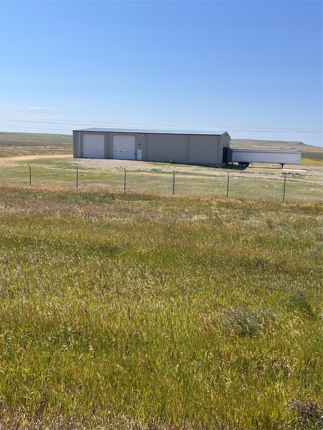 view of yard featuring an outdoor structure and a rural view