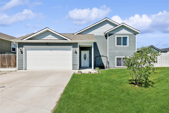 split level home with a garage, concrete driveway, a front yard, and fence